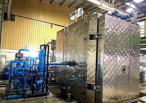 Representative image of a vacuum drying plant with insulated chamber and vacuum pump skid